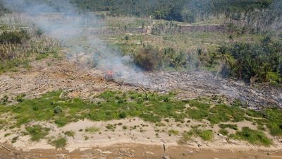 Aerial View Shows Fire Burning Flood Debris in North Aceh