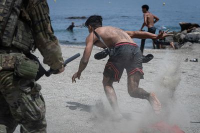 Soldier pursues migrant along beach in Ceuta